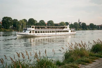Bateau de croisière fluviale naviguant sur le Danube avec des clochers en arrière-plan