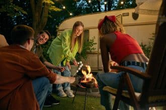Groupe d'adolescents heureux partageant un moment autour d'un feu de camp