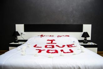 message romantique en pétales de roses sur un lit élégant