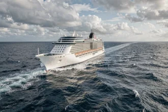 Grand paquebot de croisière traversant l'Atlantique en pleine mer avec des vagues et un ciel nuageux